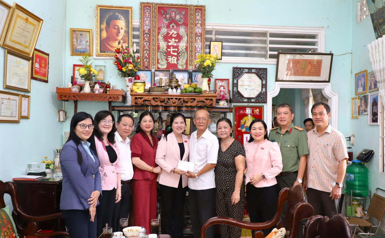 Phó Chủ tịch HĐDT Đinh Thị Phương Lan (thứ 5, từ trái qua) tặng quà và chụp hình lưu niệm với gia đình nguyên Phó Chủ tịch HĐDT Danh Út.