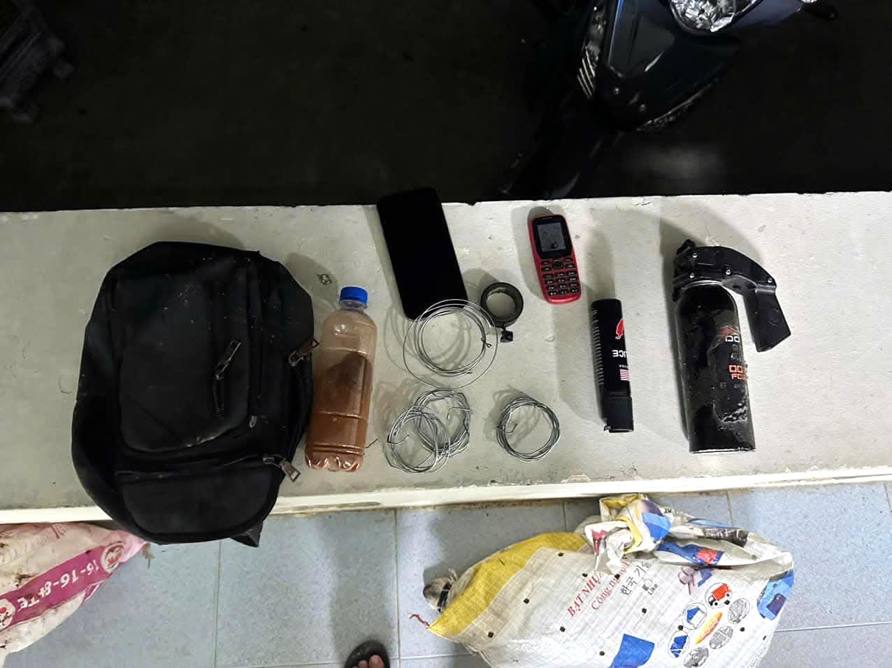 Tang vật thu giữ, gồm dây thép, bình xịt hơi cay, ớt bột và một số vật dụng liên quan.