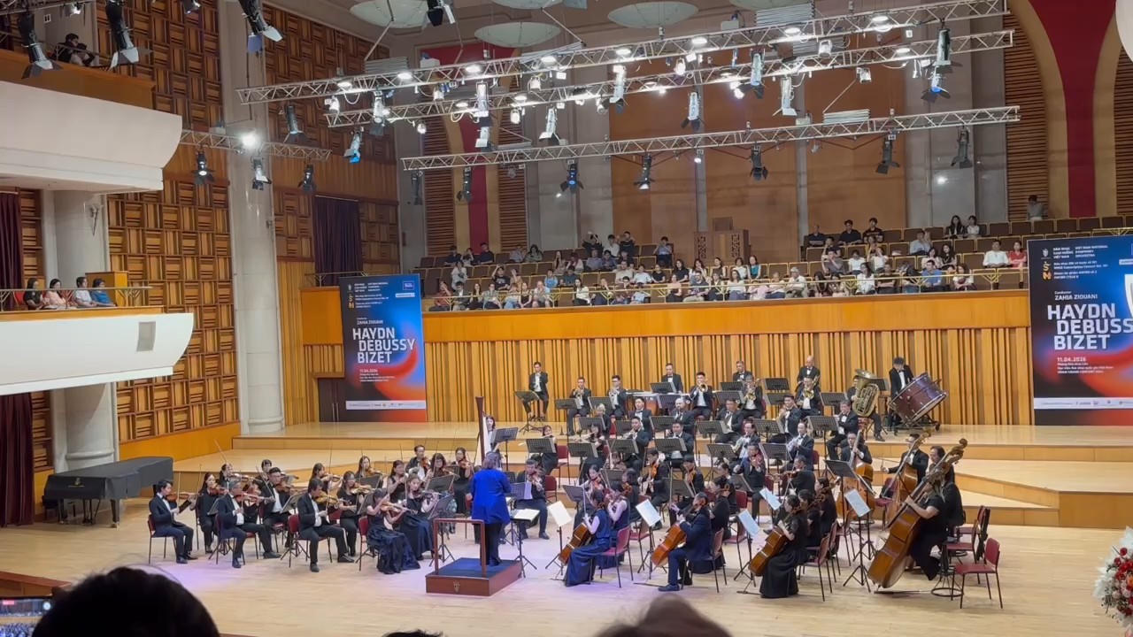 Nữ nhạc trưởng Zahia Ziouani trong khoảnh khắc chỉ huy dàn nhạc, thể hiện sự tập trung và chính xác trong từng chuyển động.