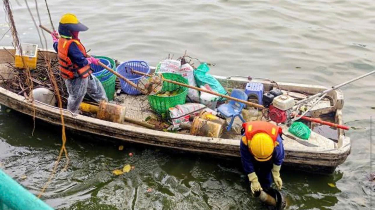 công nhân môi trường thu gom rác thải dưới Hồ Tây...