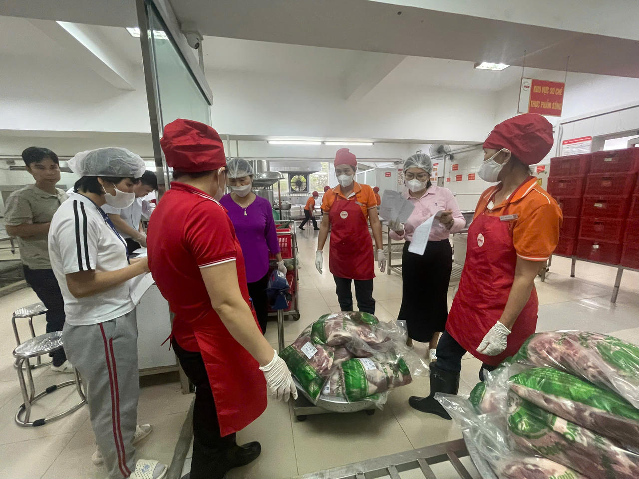 Các thành viên đoàn liên ngành kiểm tra hồ sơ pháp lý, điều kiện vệ sinh và quy trình tổ chức bếp ăn tập thể tại trường học.