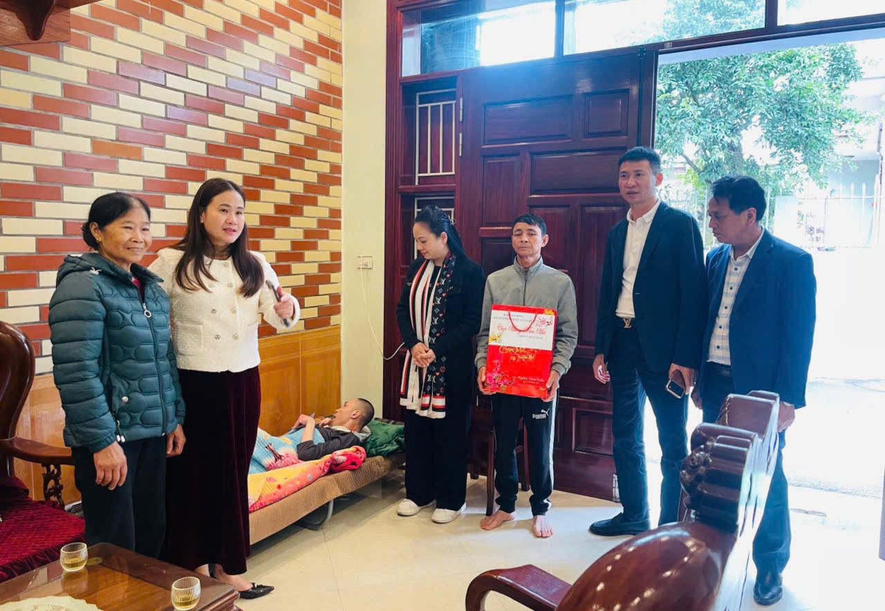 Ông Nguyễn Mạnh Cường (áo xanh) Đại diện Công ty TNHH Viết Tiến Hùng thăm hỏi, động viên em Vũ Ngọc Hưng, trú tại xã Vũ Quý, tỉnh Hưng Yên.