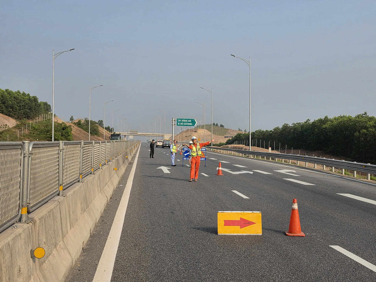 Lực lượng chức năng và công nhân điều tiết giao thông, phân luồng phương tiện trên cao tốc Vũng Áng - Cam Lộ trong thời gian tạm đóng từng đoạn để phục vụ thi công lắp đặt hệ thống.