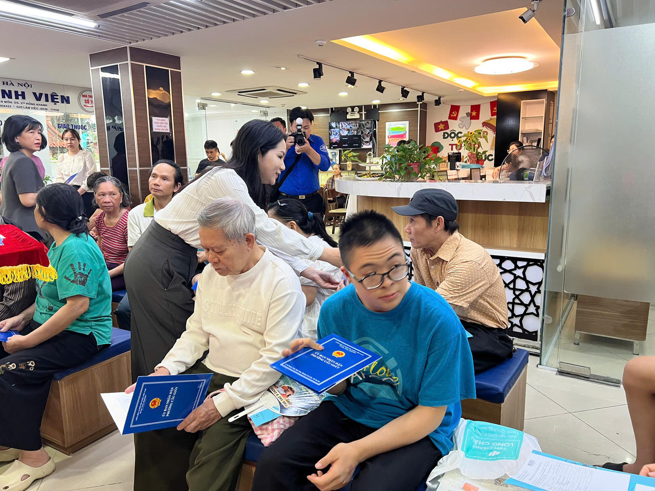 Cán bộ phường Cầu Giấy trao quà, động viên người khuyết tật tại chương trình khám sức khỏe miễn phí.