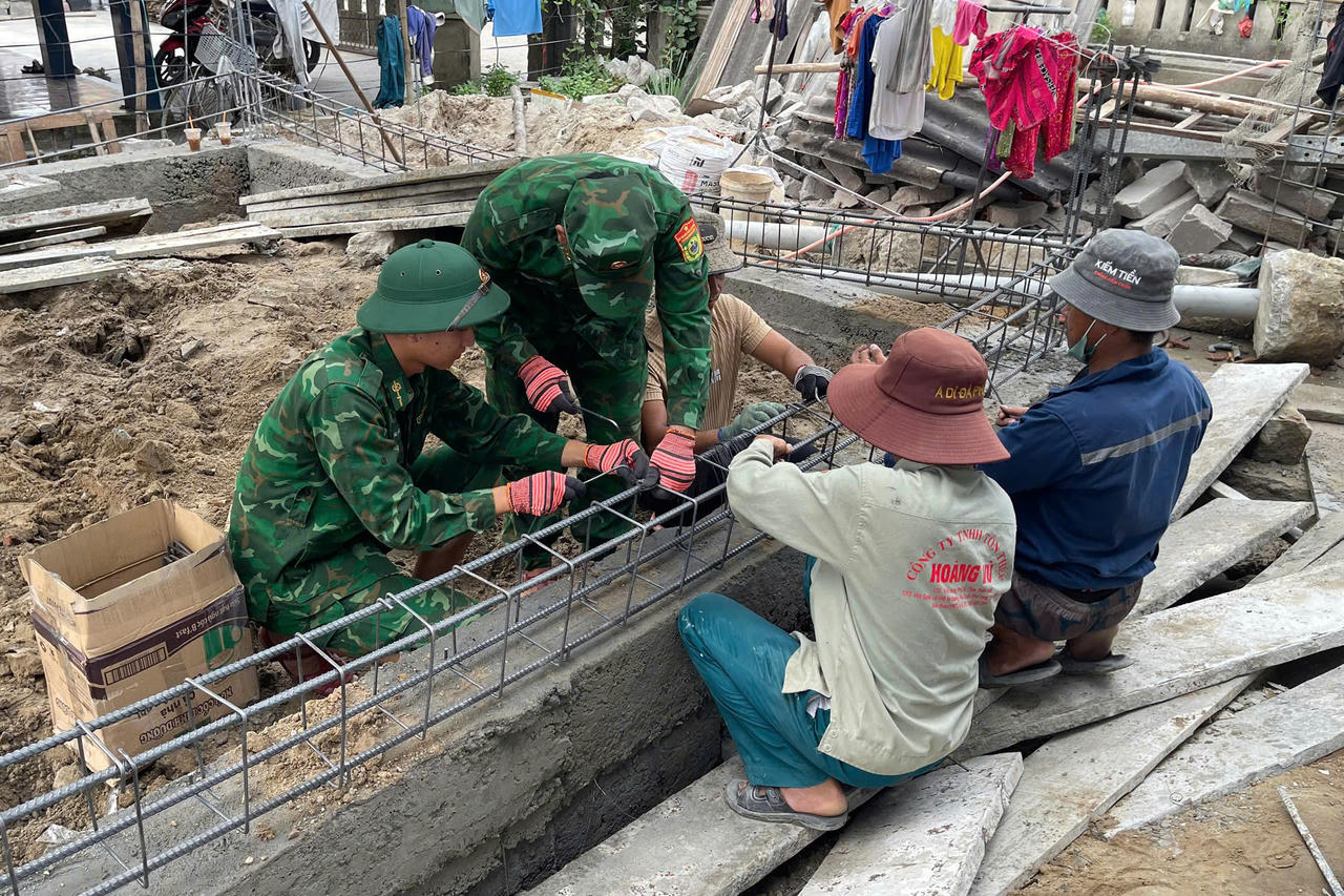 Cán bộ, chiến sĩ Đồn Biên phòng Vinh Hiền hỗ trợ người dân đổ bê tông nhà.