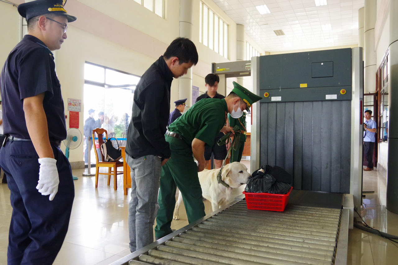 Lực lượng chức năng tại cửa khẩu quốc tế Hoa Lư, tỉnh Đồng Nai, soi chiếu hành lý của các công dân được lực lượng chức năng Campuchia trao trả. Ảnh: Thế Cường