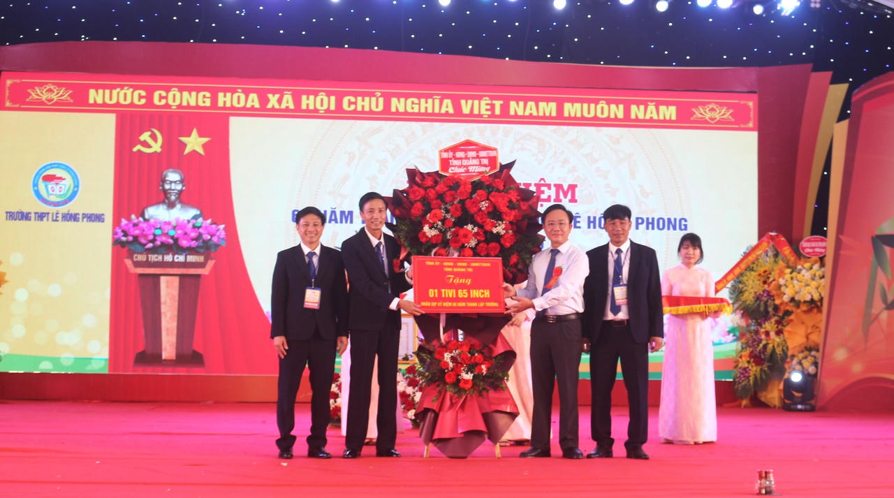 Ông Hoàng Xuân Tân, Phó Chủ tịch UBND tỉnh trao hoa và quà chúc mừng Trường THPT Lê Hồng Phong.