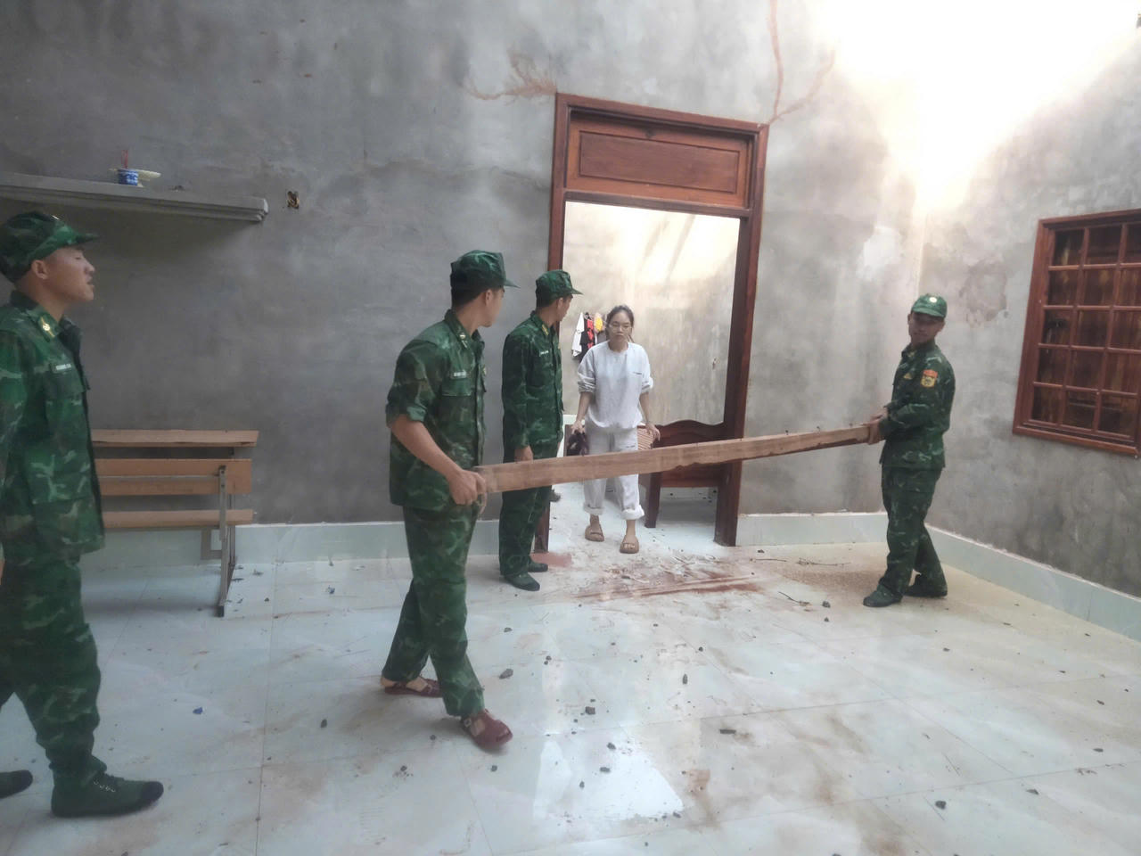 Lực lượng Biên phòng Ba Nang giúp người dân thu dọn vật dụng, gia cố lại nhà cửa sau khi bị lốc xoáy tàn phá.