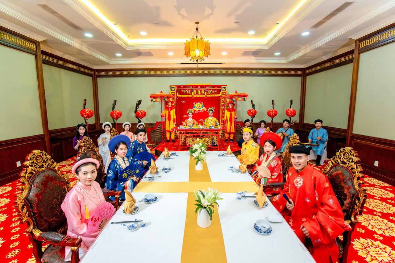 Du khách khoác lên người trang phục cung đình và thưởng thức “cơm vua” giữa không gian Nhã nhạc cung đình Huế tại TTC Imperial Hotel.