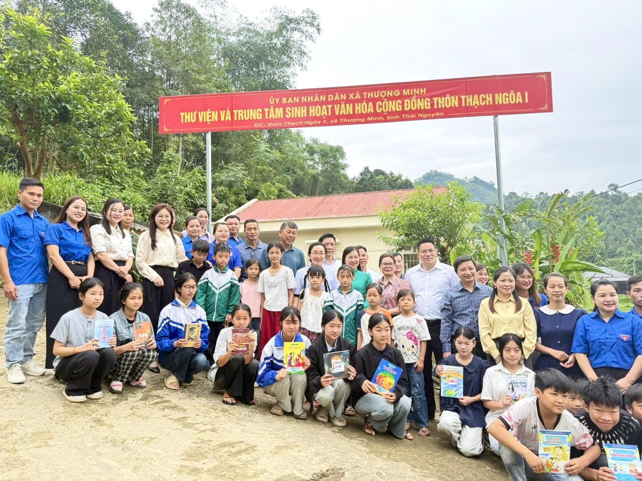 Các đại biểu chụp ảnh cùng các em học sinh tại điểm thư viện và trung tâm sinh hoạt văn hóa cộng đồng thôn Thạch Ngõa - xã Thượng Minh. (Ảnh: Lê Hanh)