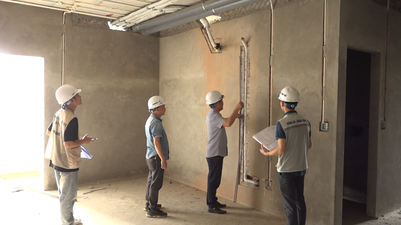 Đội ngũ kỹ sư và giám sát công trình đang kiểm tra cao độ và độ thẳng của hệ thống ống kỹ thuật âm tường.