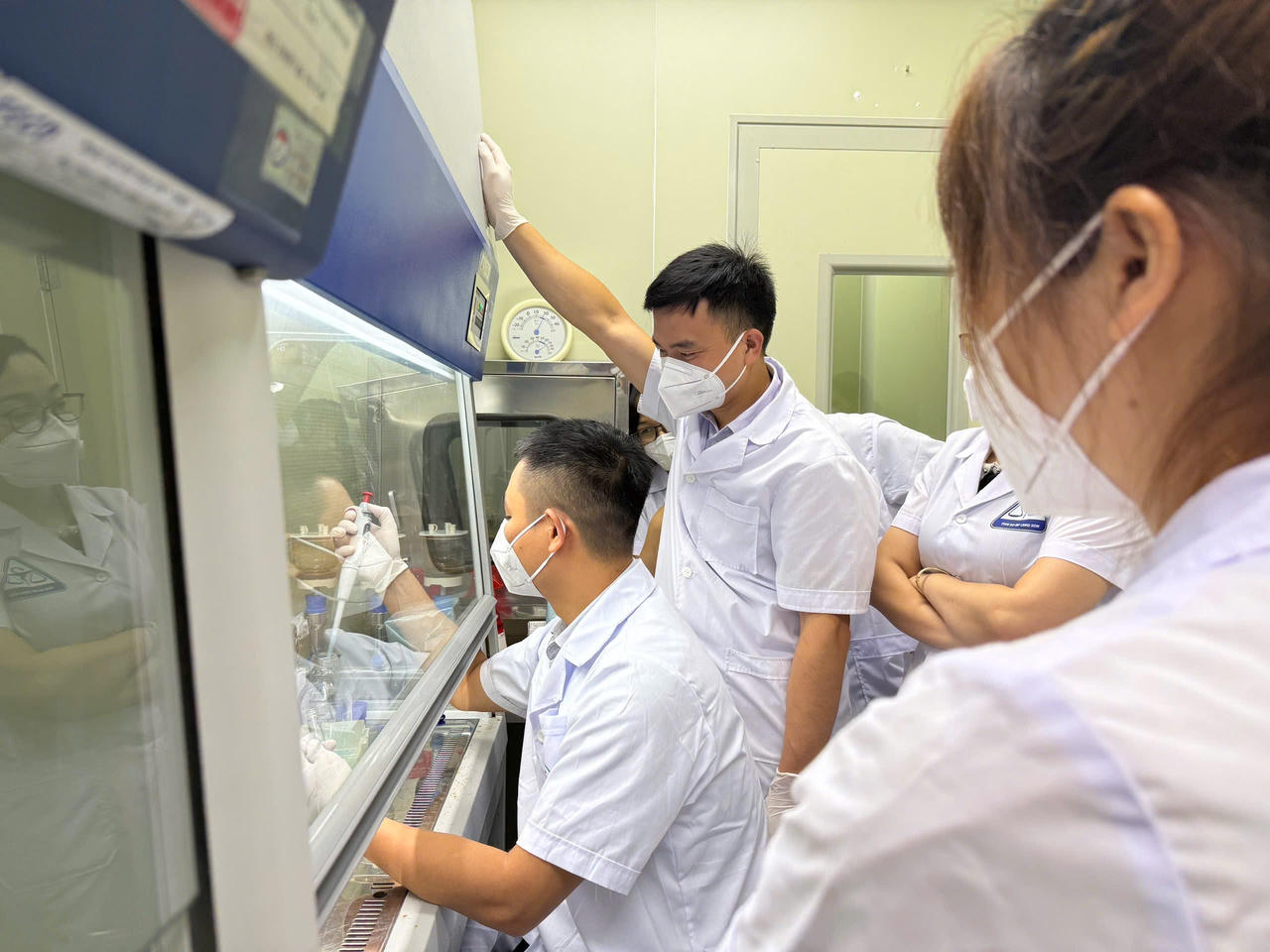 Các kiểm nghiệm viên của trung tâm đang theo dõi hướng dẫn kiểm nghiệm của cán bộ Viện ATTP Quốc gia. (Ảnh: TTCC)