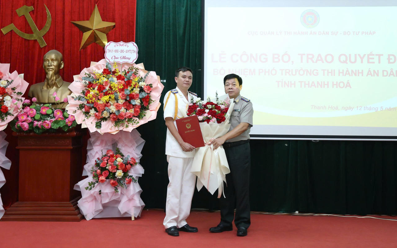 Ông Trần Văn Dũng, Trưởng Thi hành án dân sự tỉnh Thanh Hóa trao Quyết định và tặng hoa chúc mừng tân Phó Trưởng Thi hành án dân sự tỉnh Thanh Hóa Lê Viết Tám.