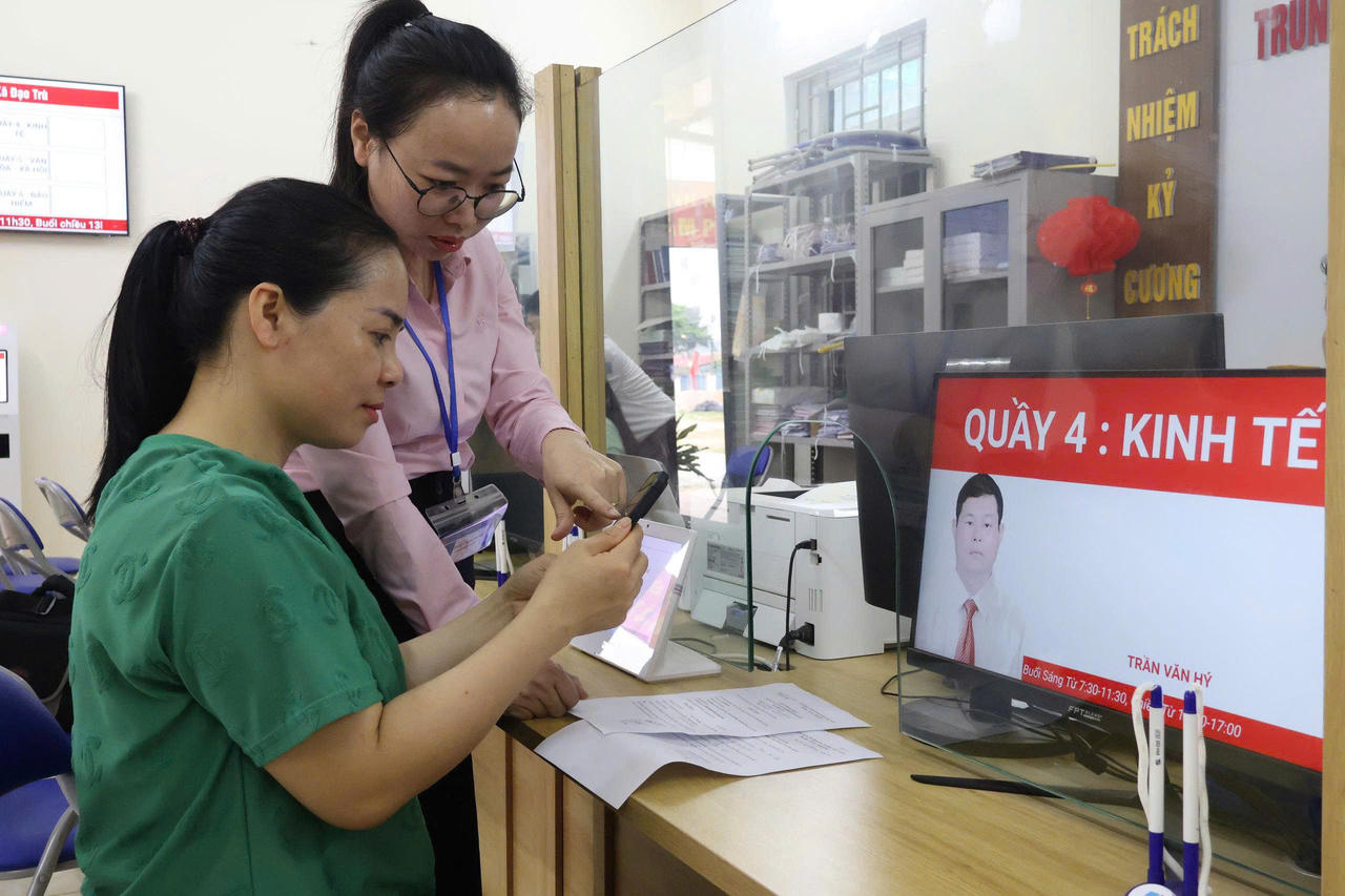 Cán bộ Trung tâm phục vụ hành chính công xã Đạo Trù hướng dẫn người dân thực hiện thủ tục hành chính trên VneID.
