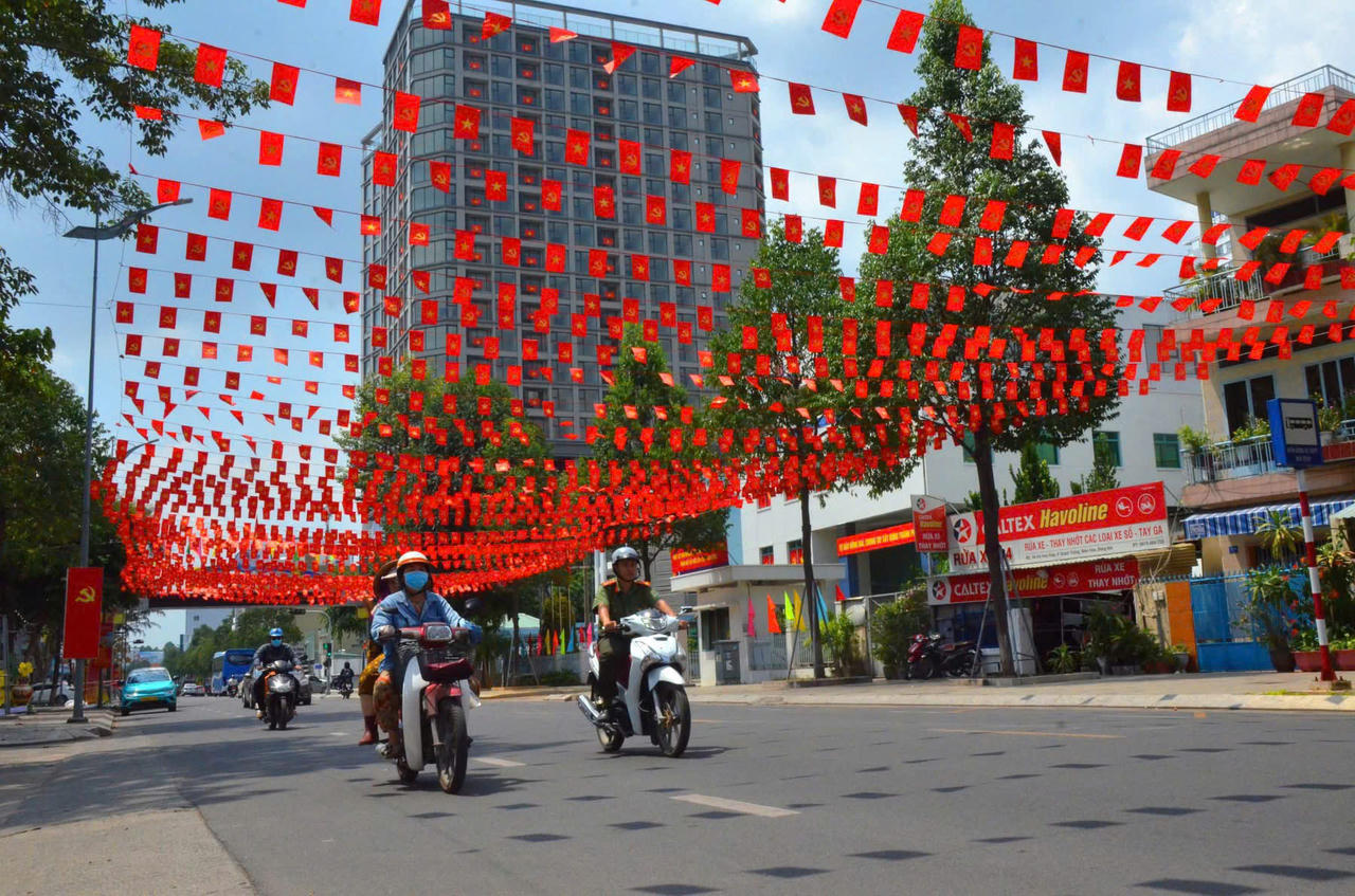 Người dân di chuyển trong không khí phấn khởi trên những cung đường rợp bóng cờ bay.