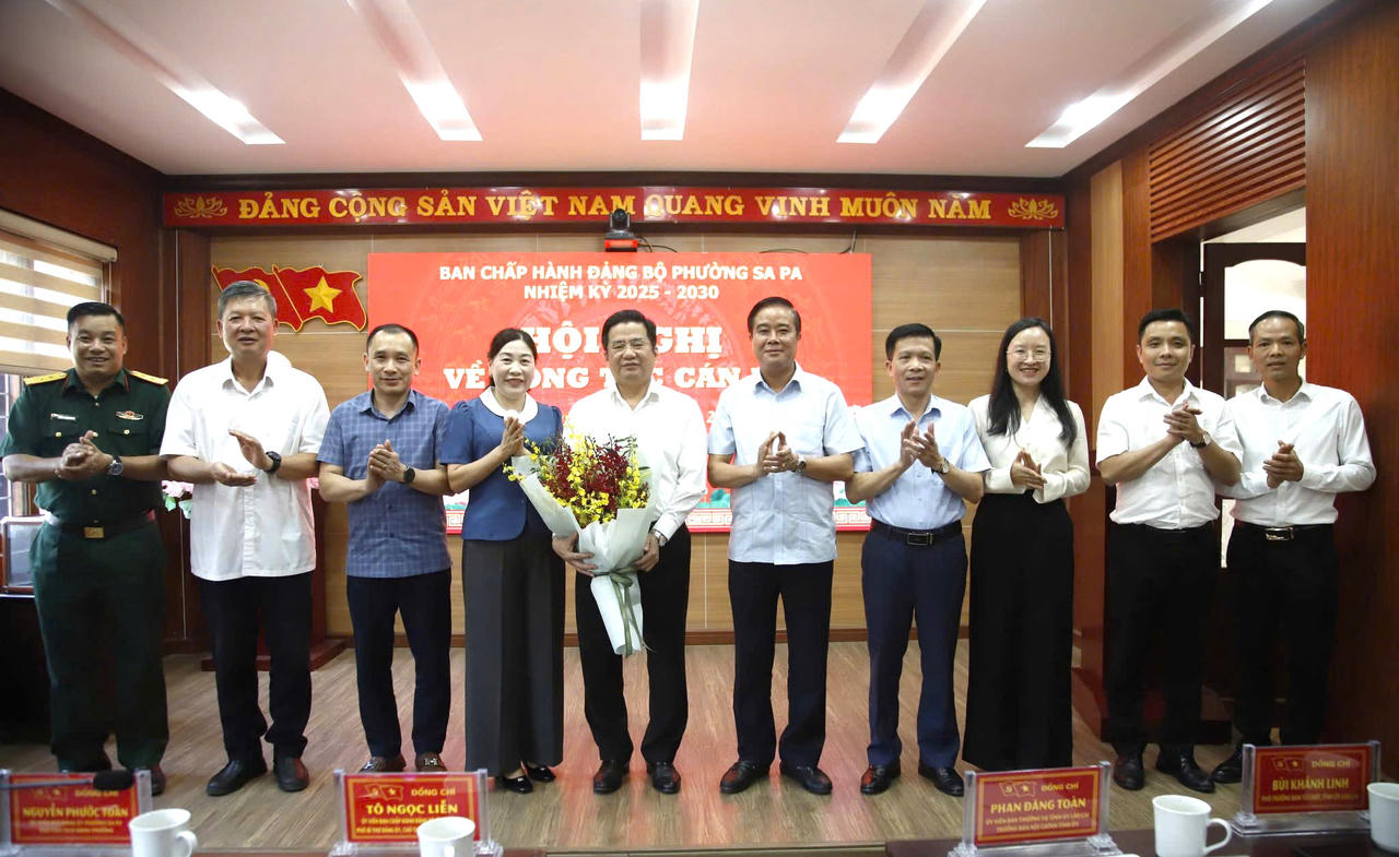 Các đại biểu tặng hoa chúc mừng tân Bí thư Đảng ủy phường Sa Pa Tô Ngọc Liễn.