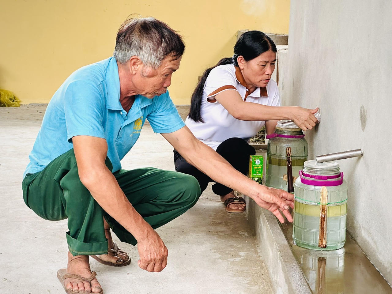 Vợ chồng chị Giáo Vượng kiểm tra chất lượng tinh dầu sau quá trình chưng cất.