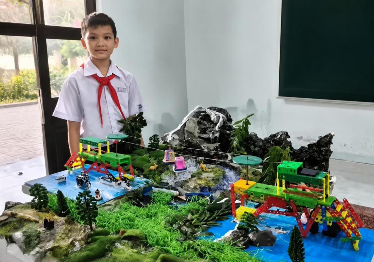 Em Nguyễn Hoàng Thiên Phú bên mô hình “Cáp treo hỗ trợ học sinh vùng cao đến trường” – sản phẩm giành giải Nhất cá nhân tại cuộc thi “Tìm kiếm Kĩ sư nhí – Mùa 2”.