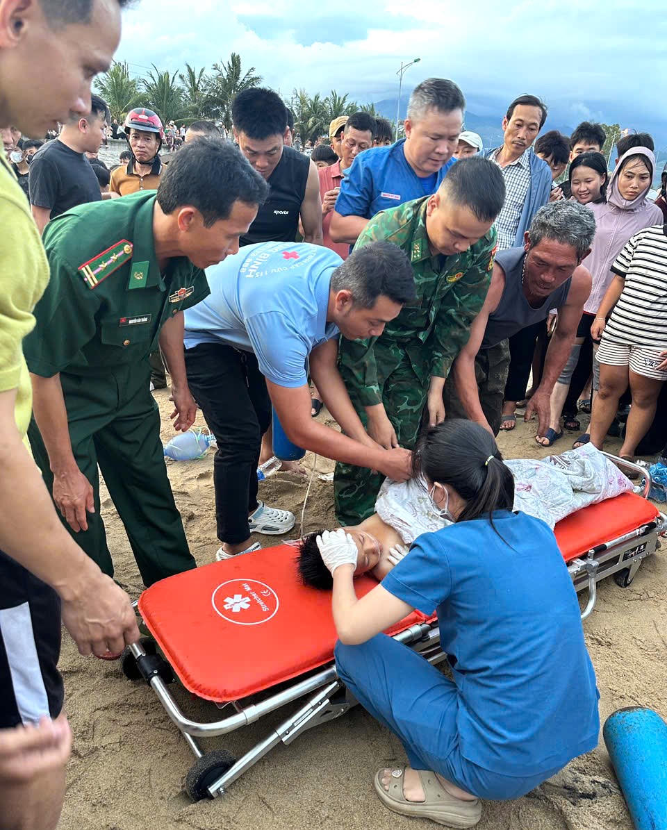 Bộ đội Biên phòng, nhân viên y tế và người dân phối hợp sơ cứu, đưa cháu bé bị sóng cuốn tại bãi biển Hòa Trạch đi cấp cứu.