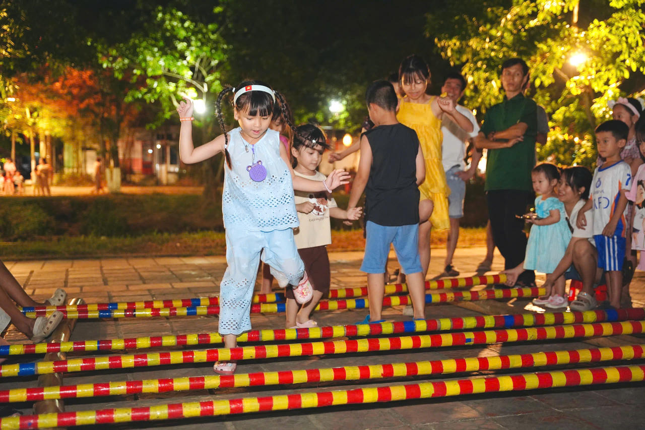 Tiếng cười rộn rã của con trẻ khi tham gia các hoạt động trải nghiệm, trò chơi dân gian trong không gian chợ quê.