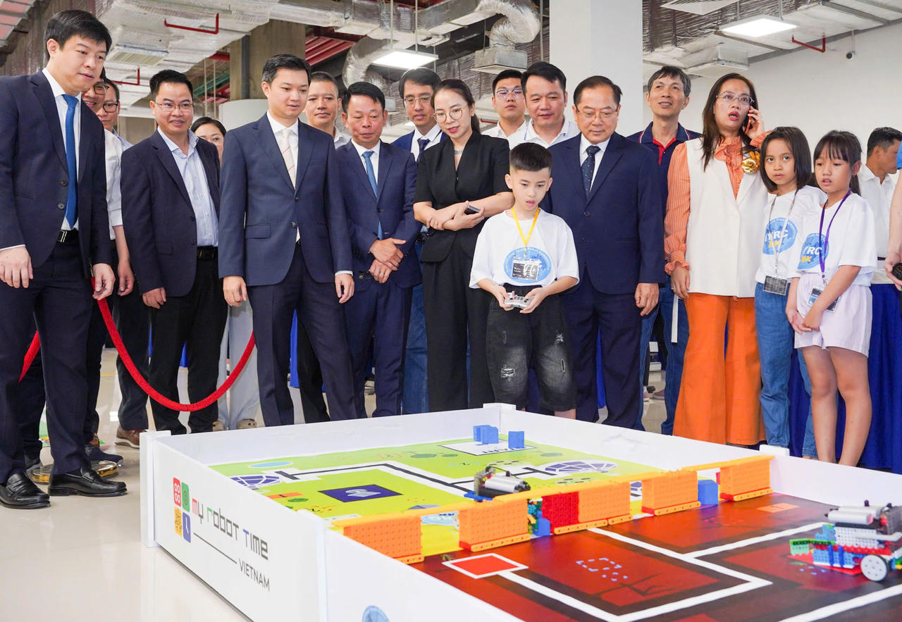 Lãnh đạo các cấp và đại biểu tham quan, động viên phần trình diễn điều khiển robot thông minh của học sinh Trường Tiểu học Kim Đồng.