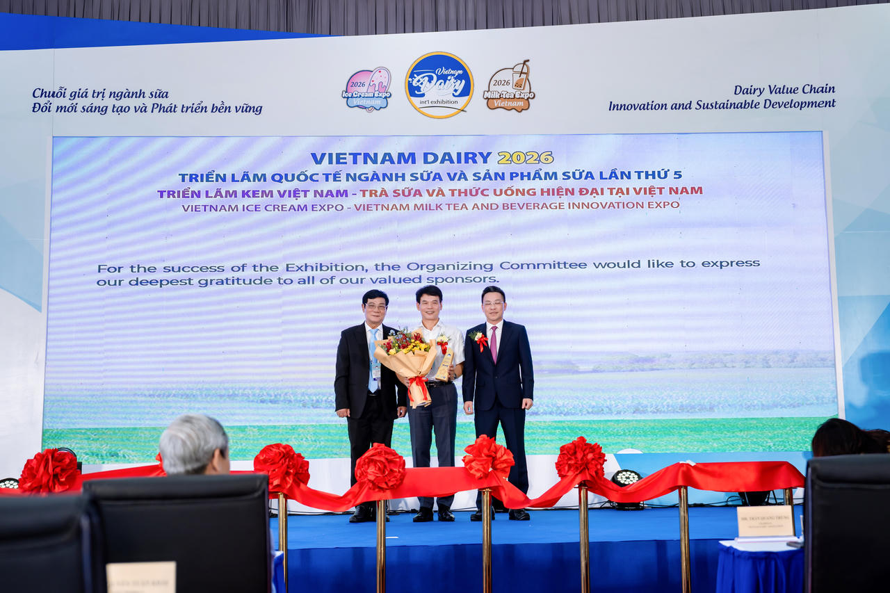 Ông Phạm Tuyên – Giám đốc chi nhánh Vinamilk Hà Nội (áo trắng) – nhận hoa và kỷ niệm chương của Ban tổ chức (Ảnh: Duy Cường).