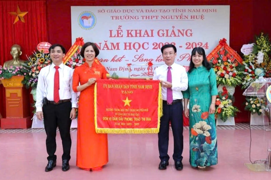 Ông Phạm Đình Nghị, nguyên Chủ tịch UBND tỉnh Nam Định tặng cờ cho đơn vị dẫn đầu phong trào thi đua năm học 2022-2023.