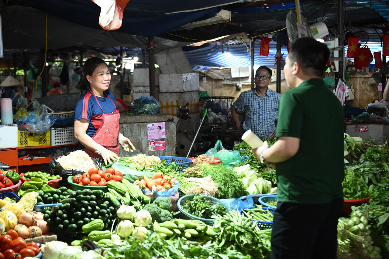 Chị Nguyễn Thị Thu (Chợ Đồng Xa, Hà Nội) được nhân viên VPBank hướng dẫn mở tài khoản hộ kinh doanh ngay tại quầy hàng