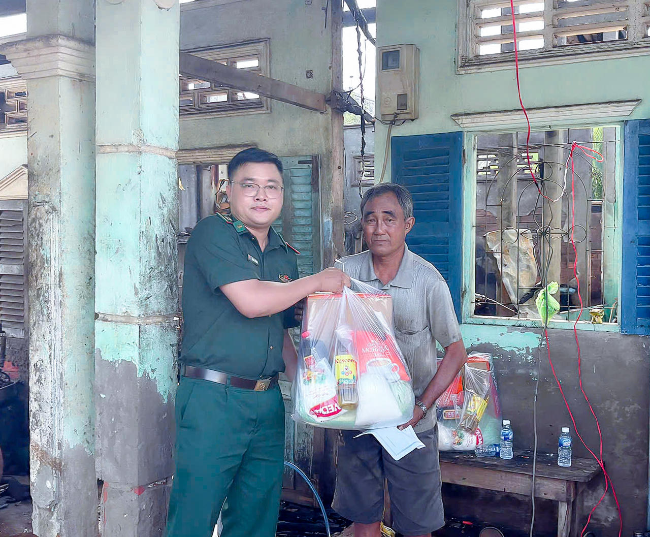Thiếu tá Huỳnh Lý Tưởng - Chính trị viên đồn Biên phòng Trung Bình, đến thăm hỏi động viên và tặng quà cho 2 hộ gia đình bị hỏa hoạn