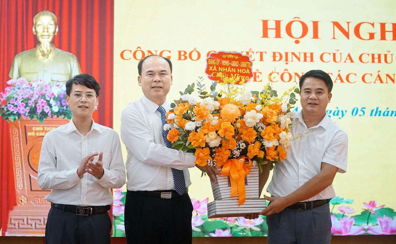 Đại diện Đảng ủy - HĐND - UBND xã Nhân Hòa tặng hoa chúc mừng nguyên Bí thư Đảng ủy xã nhận nhiệm vụ mới. Ảnh: Tuyết Lan