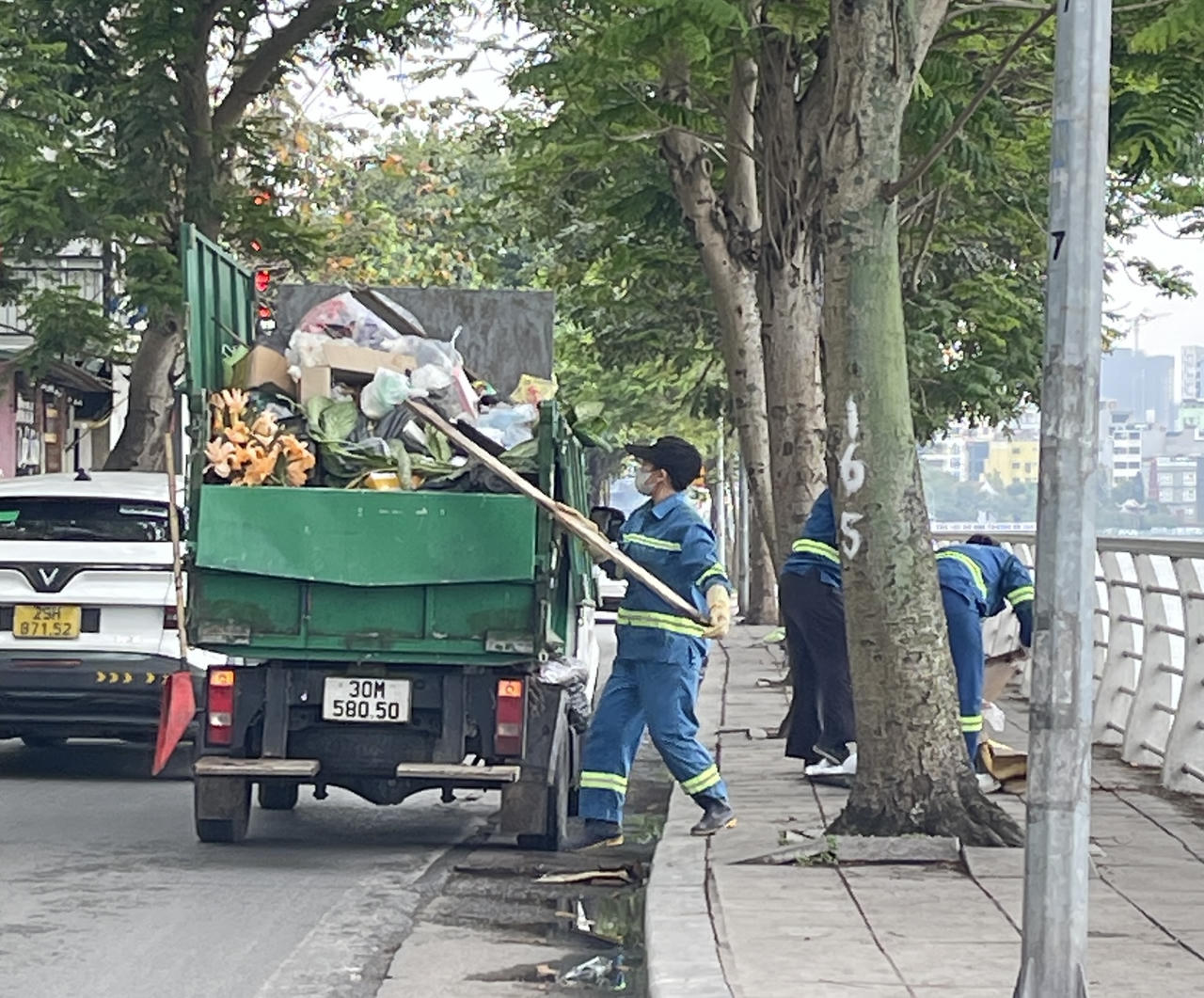 Lực lượng vệ sinh môi trường thu gom rác quanh Hồ Tây.