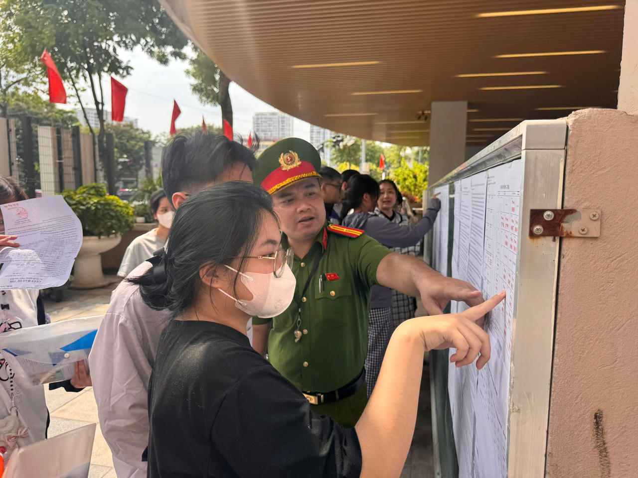 Cán bộ chiến sỹ trẻ trực tiếp hướng dẫn thí sinh tra cứu thông tin phòng thi .