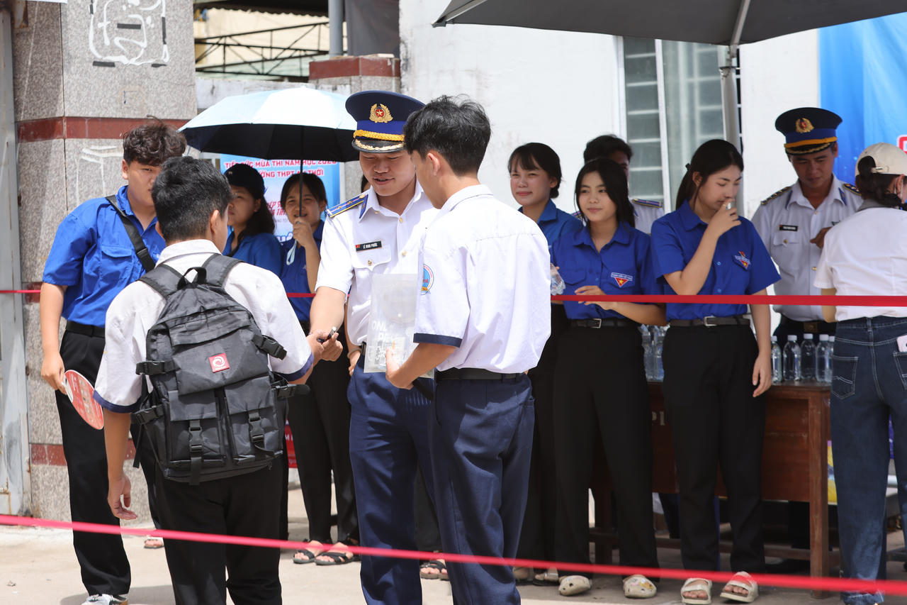 Cán bộ, đoàn viên Hải đội 401 động viên, tặng bút viết cho thí sinh tại điểm thi.
