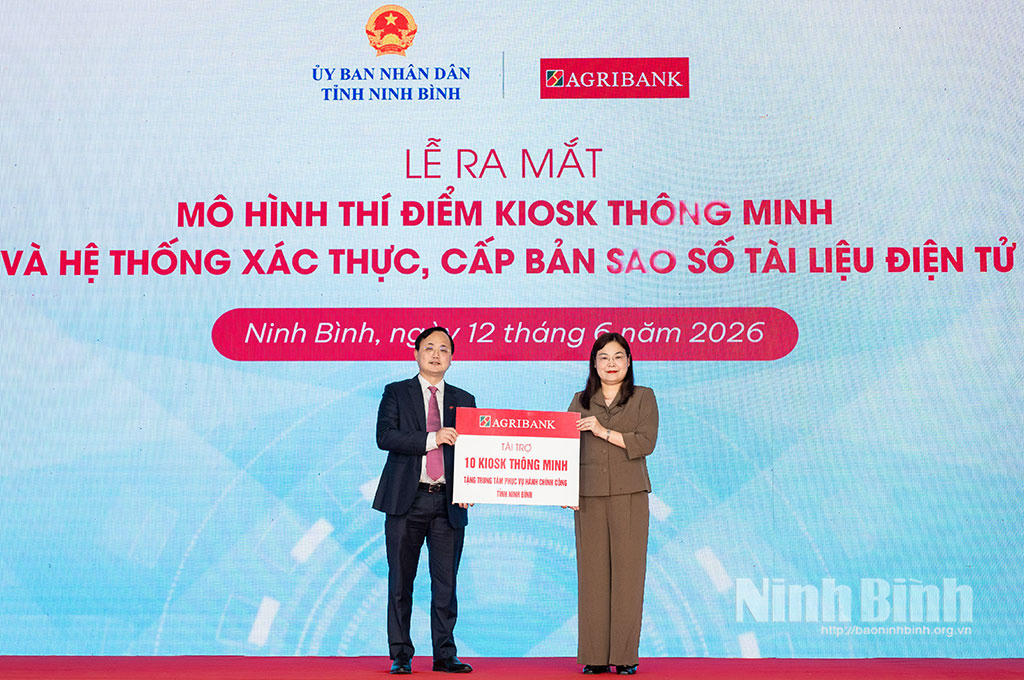Ông Tô Huy Vũ, Chủ tịch Hội đồng thành viên Agribank Việt Nam trao biểu trưng 10 Kiosk Hành chính công thông minh cho bà Hà Lan Anh, Phó Chủ tịch UBND tỉnh Ninh Bình.&nbsp;Ảnh: Nguyễn Hương-Ngọc Linh
