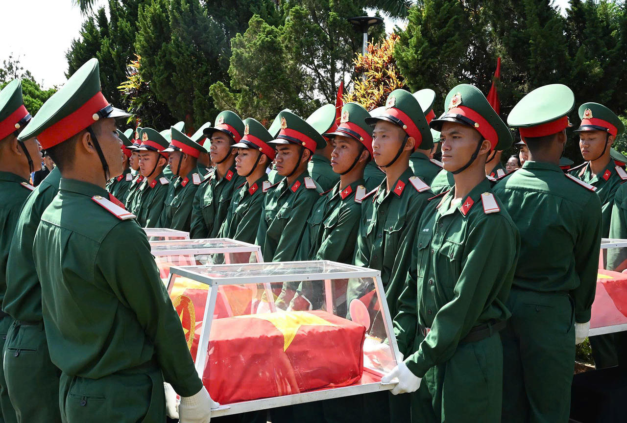 Lực lượng chức năng thực hiện nghi thức an táng các hài cốt liệt sĩ.