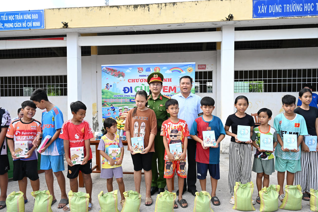 Công an phường Vĩnh Trạch và chính quyền địa phương trao quà cho học sinh có hoàn cảnh khó khăn trong chương trình “Đi cùng em”.