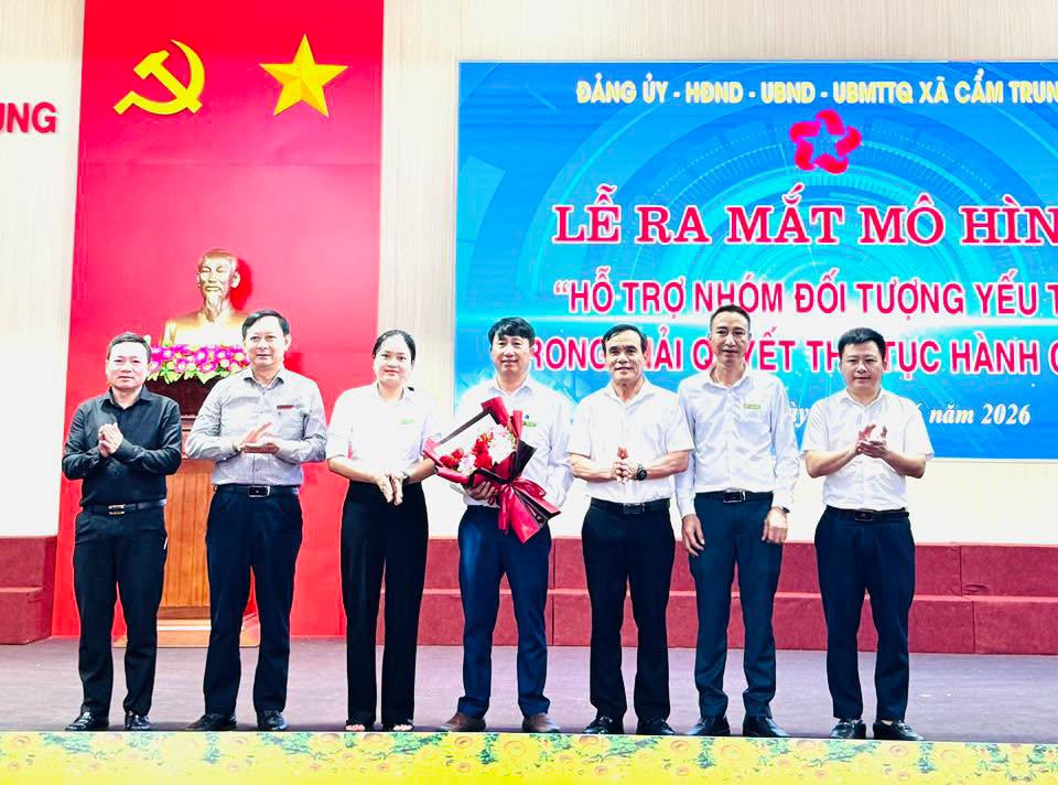 Lãnh đạo Ban Tuyên giáo và Dân vận Tỉnh ủy Hà Tĩnh cùng lãnh đạo xã Cẩm Trung tặng hoa chúc mừng các thành viên tổ hỗ trợ nhóm đối tượng yếu thế trong giải quyết thủ tục hành chính. (Ảnh: Cao Nhung)