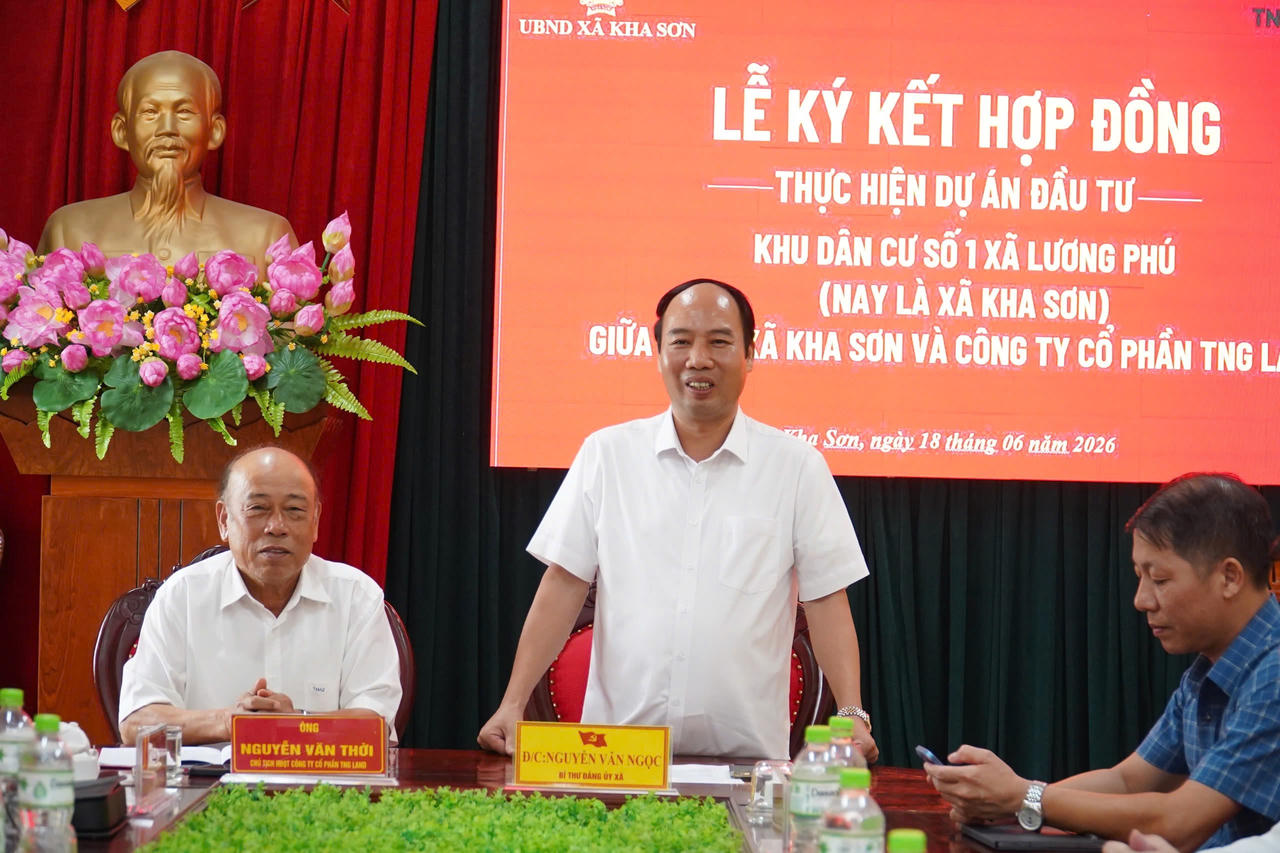 Ông Nguyễn Văn Thời (trái) và đồng chí Nguyễn Văn Ngọc trao đổi tại bàn chủ tọa trong Lễ ký kết hợp đồng giữa UBND xã Kha Sơn và Công ty Cổ phần TNG Land.