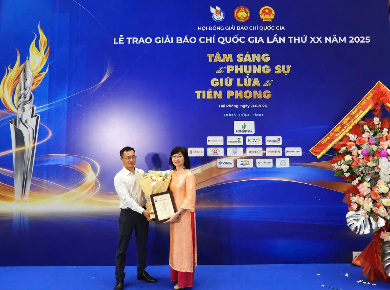 Nhà báo Trần Ngọc Hà - Phó Tổng biên tập, đại diện lãnh đạo Ban biên tập Báo Pháp luật Việt Nam tặng hoa Nhà báo Lương Thị Vân Anh - tác giả loạt bài giành giải Khuyến khích.