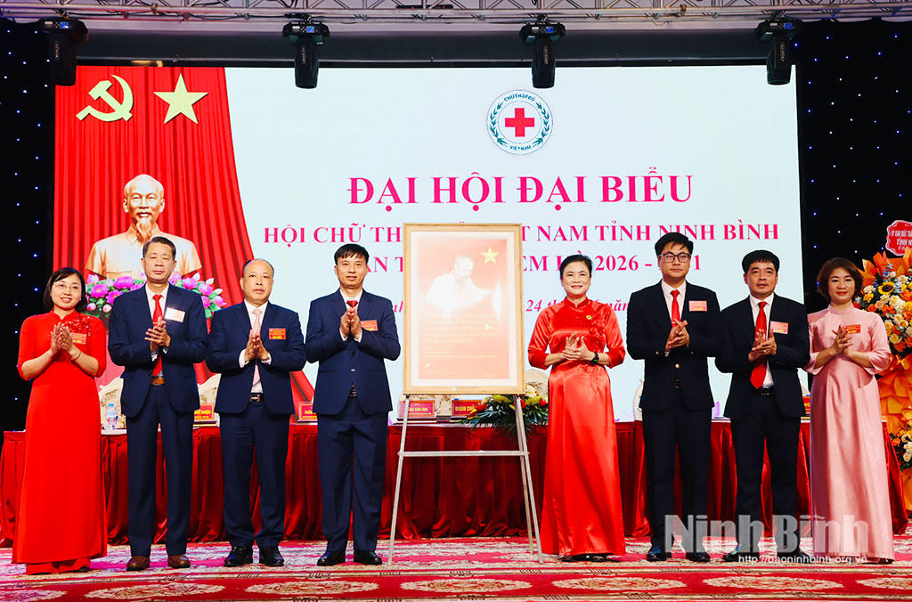 Bà Đỗ Thị Thu Thảo, Bí thư Đảng ủy, Chủ tịch Trung ương Hội Chữ thập đỏ Việt Nam trao bức tranh Bác Hồ tặng Đại hội. (Ảnh: Diệu Linh - Đức Lam)