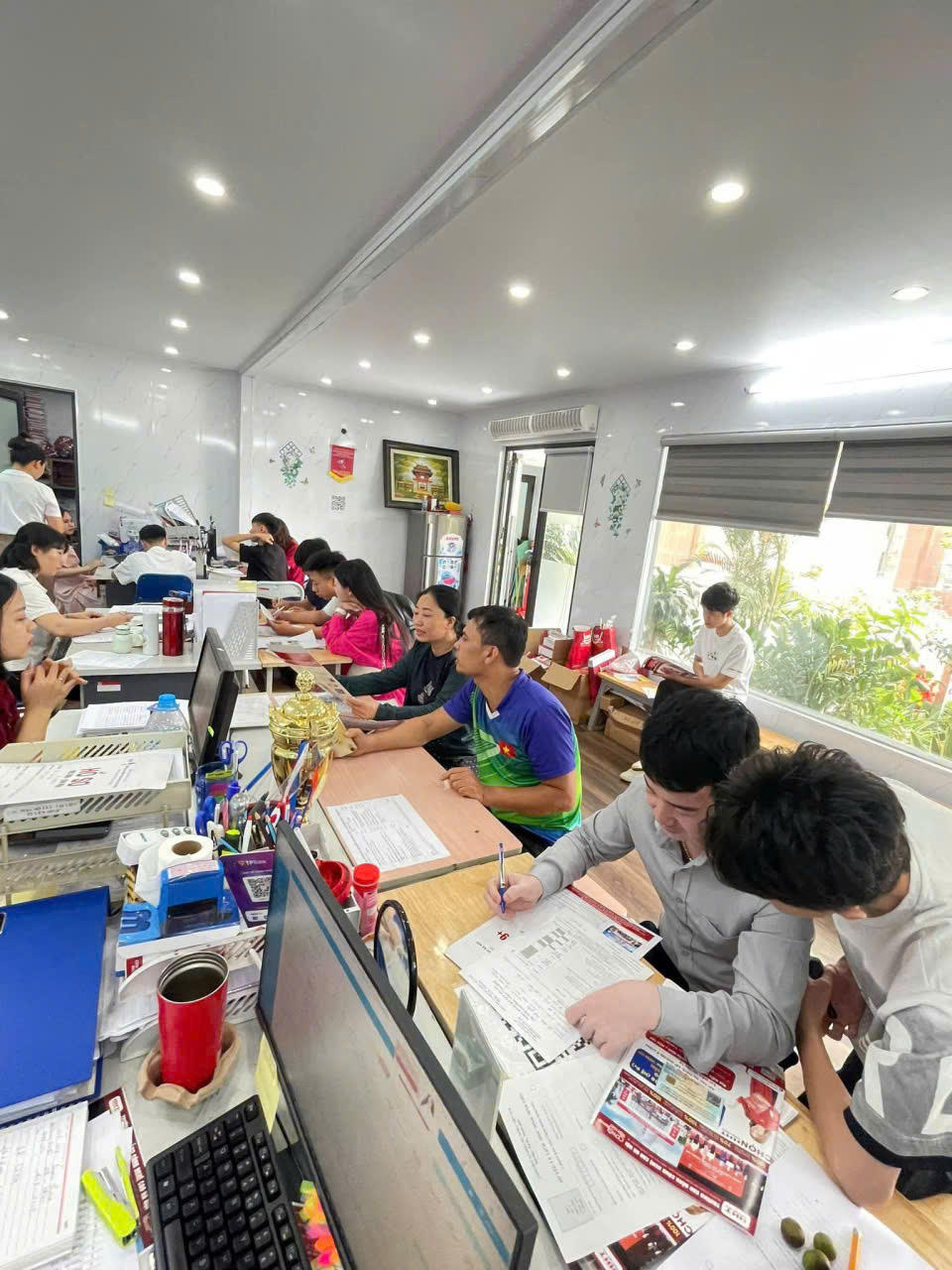 Phụ huynh và học sinh xếp hàng làm thủ tục tại bàn tuyển sinh.