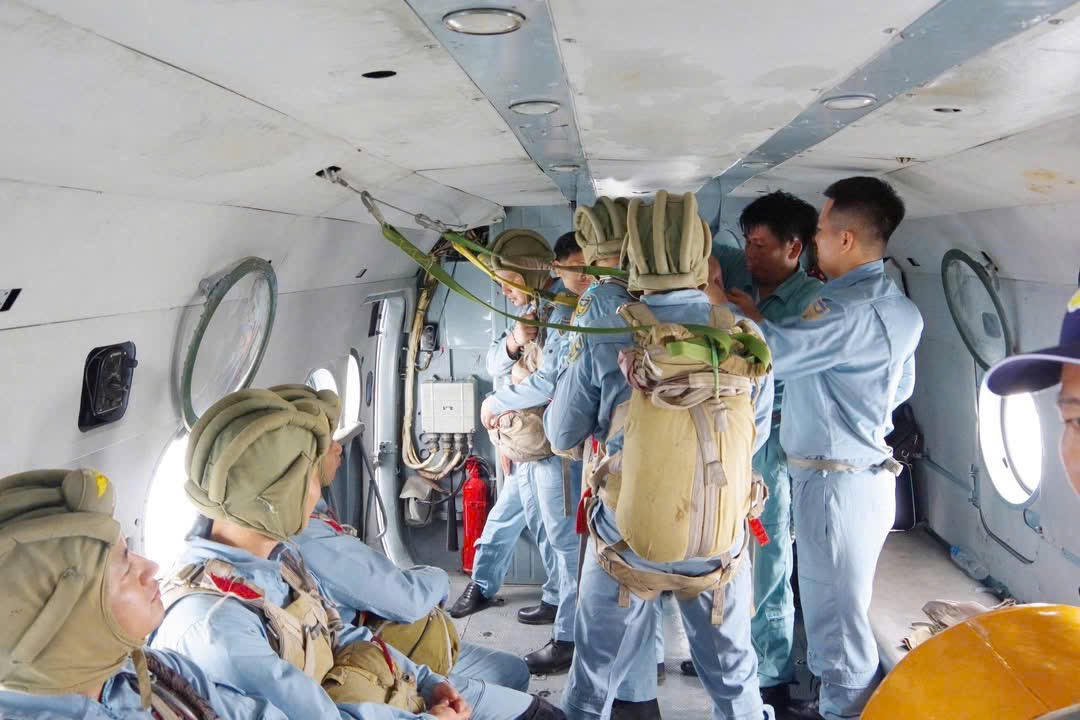 Phi công, thành viên tổ bay, trợ lý và nhân viên dù chuẩn bị thực hiện động tác nhảy dù từ máy bay.