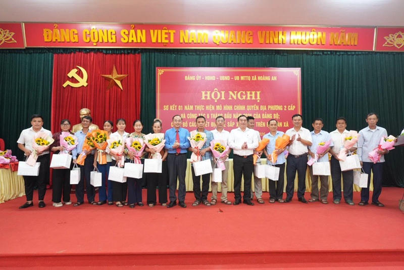 Lãnh đạo xã tặng quà, hoa cho Bí thư, Trưởng thôn, Trưởng ban CTMT của 28 thôn cũ nghỉ việc (Ảnh: Trang TT xã Hoàng An).