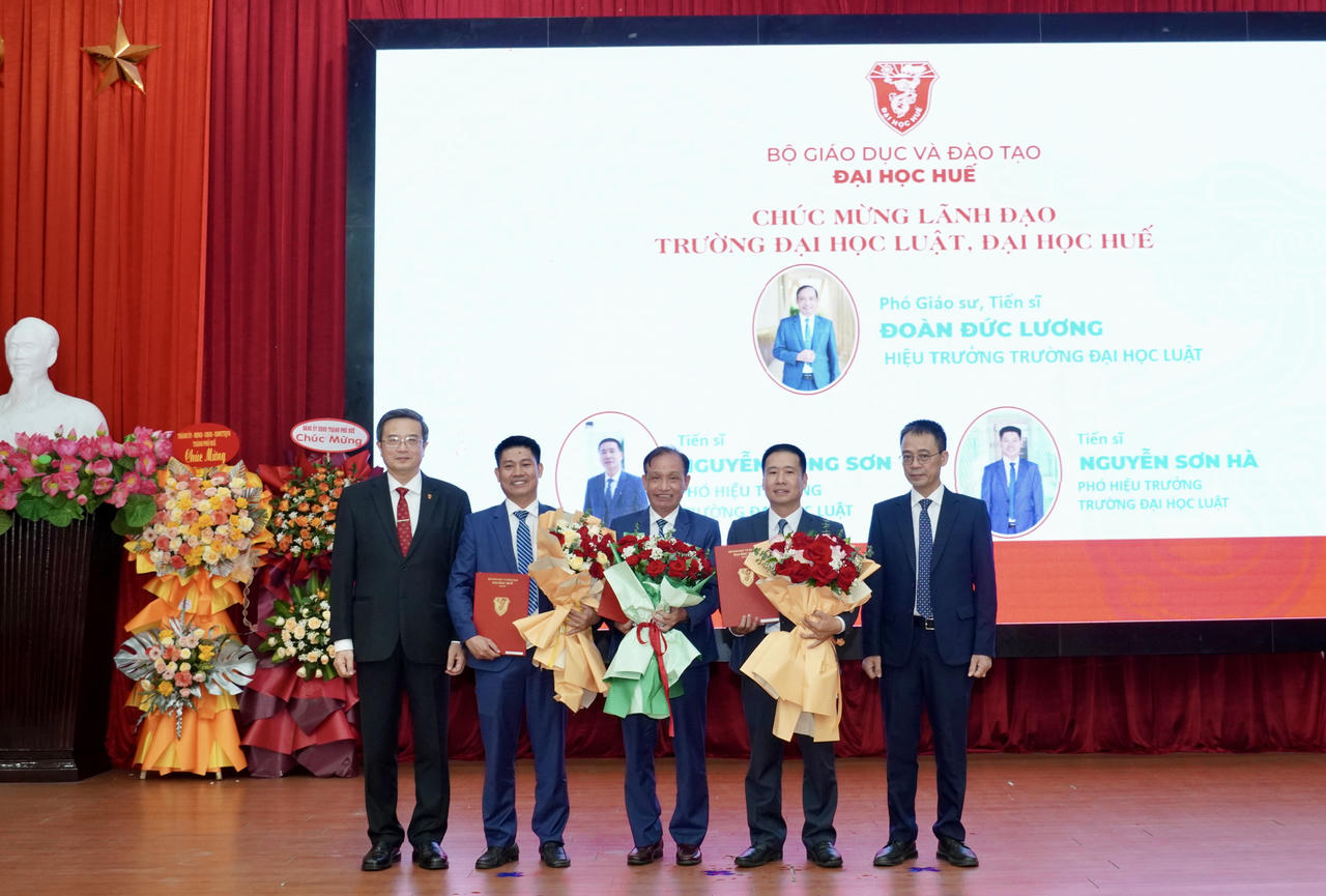 Phó GS.TS Đoàn Đức Lương (đứng giữa) cùng 2 tân Phó hiệu trưởng ĐH Luật nhận quyết định và hoa của LĐ ĐH Huế