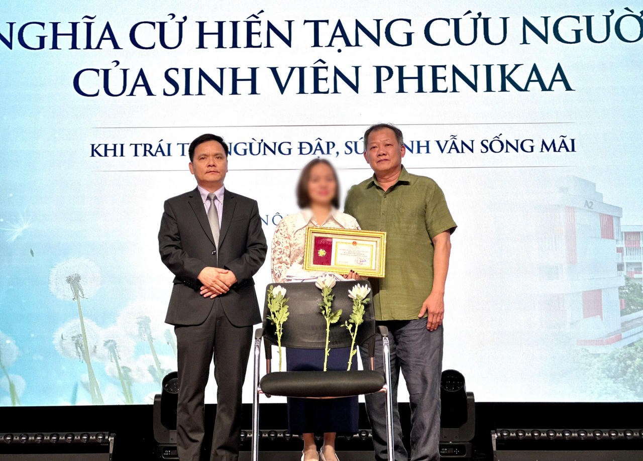 Đại diện Lãnh đạo Trường Y - Dược Phenikaa và Bệnh viện Hữu nghị Việt Đức cùng thực hiện nghi thức trao lại chiếc áo blouse trắng và Bằng khen của Bộ Y tế cho gia đình