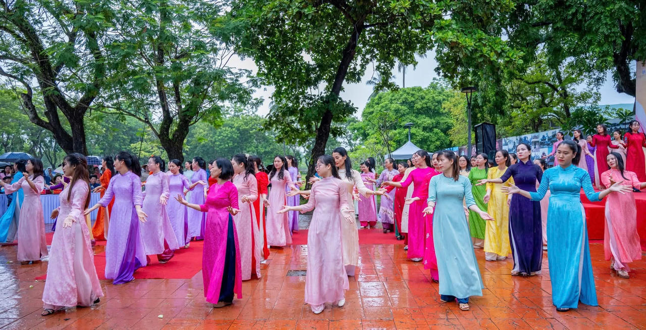 Dù thời tiết có mưa dông, màn đồng diễn dân vũ của các hội viên phụ nữ trong tà áo dài truyền thống vẫn diễn ra nhịp nhàng, uyển chuyển, thu hút sự theo dõi của người dân và du khách.