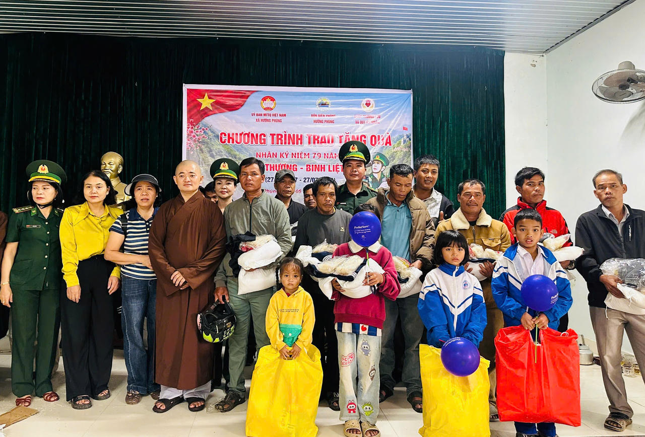 Đại diện các đơn vị phối hợp và người dân chụp ảnh lưu niệm tại chương trình trao quà nhân kỷ niệm 79 năm Ngày Thương binh - Liệt sĩ.