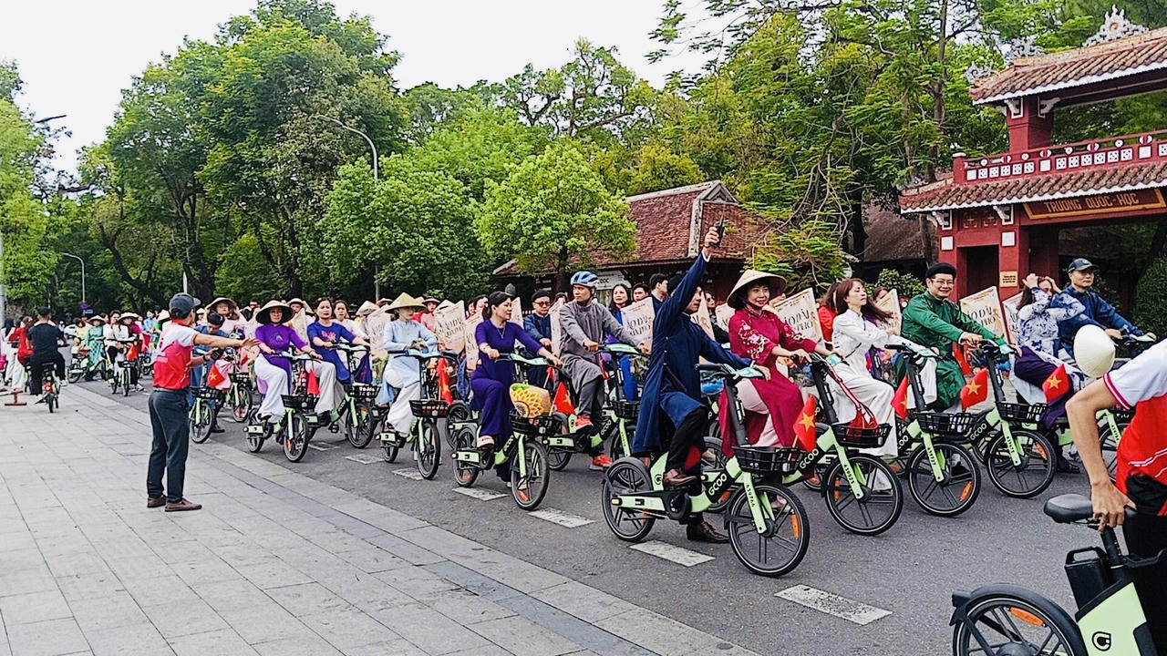 Hơn 200 đại biểu, cán bộ, người lao động và doanh nghiệp du lịch tham gia hoạt động đạp xe trong trang phục áo dài truyền thống.