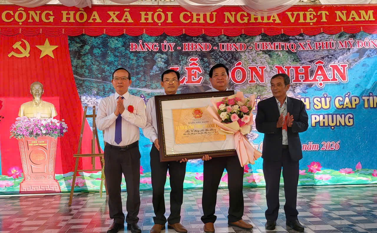 Lãnh đạo xã Phù Mỹ Đông đón nhận Bằng xếp hạng di tích cấp tỉnh mũi Vi Rồng - núi Tân Phụng. (Ảnh: Việt Lợi)