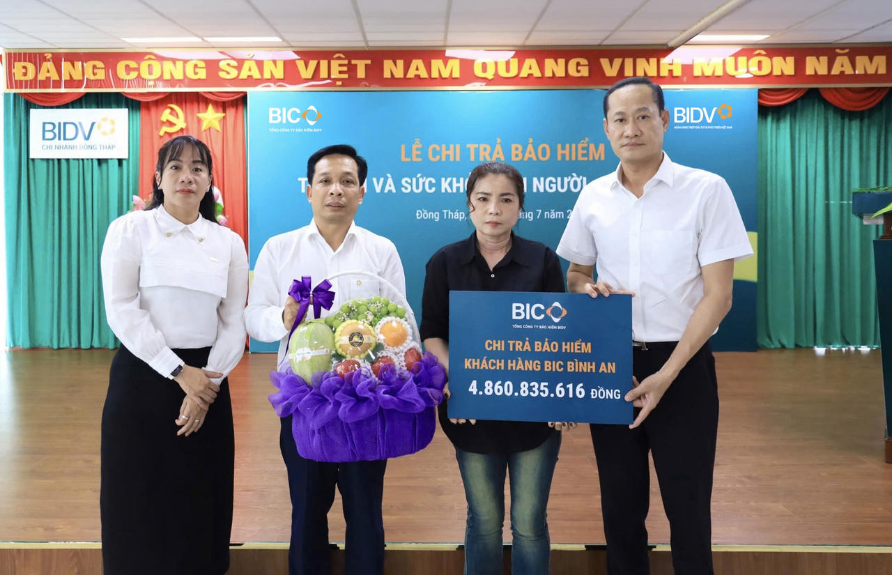Đại diện lãnh đạo BIC và BIDV Đồng Tháp trao tiền bảo hiểm cho đại diện khách hàng